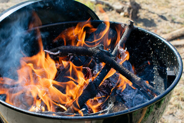 Vivid flames and smoldering wood in a barbecue grill, ideal for summer cookouts and outdoor gatherings