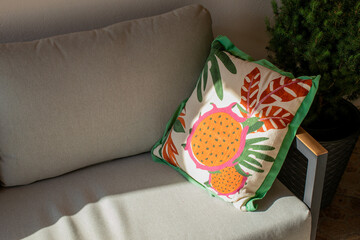 Colorful tropical fruit-themed pillow on a cozy sofa, perfect for summer home decoration or...