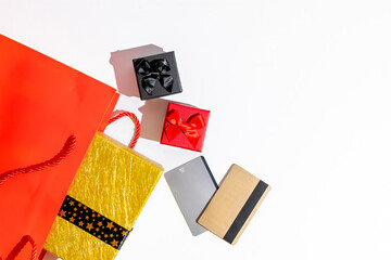 Colorful gift bags, wrapped presents, and credit cards symbolize holiday shopping and gift-giving for Christmas or Black Friday deals