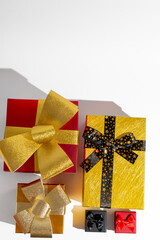 Brightly wrapped Christmas presents with gold and black bows casting shadows, perfect for holiday celebration and gift-giving themes