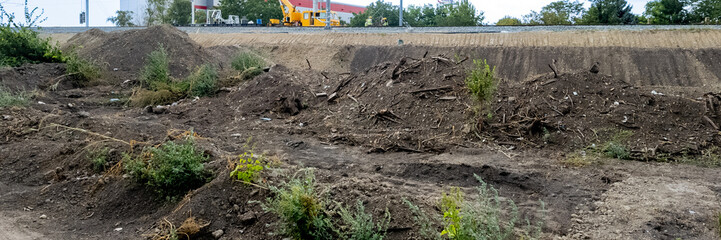 Fototapeta premium Construction site with large piles of dirt and debris, showcasing land preparation and environmental impact for urban development