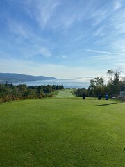 Blue skies and green golf course with mountain and ocean view