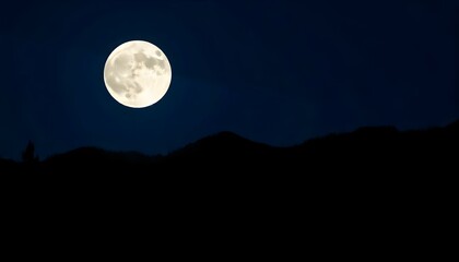 A full moon in a night sky over a silhouetted mountain landscape with pine trees