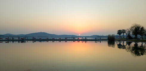 Fototapeta premium Serene Sunset Reflection Over Calm Waters in a Tranquil Landscape