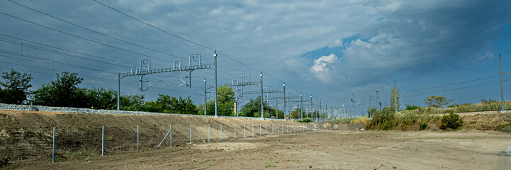 Fototapeta premium Empty dirt lot with overcast skies near train tracks, potentially depicting industrial wasteland or abandoned rail project