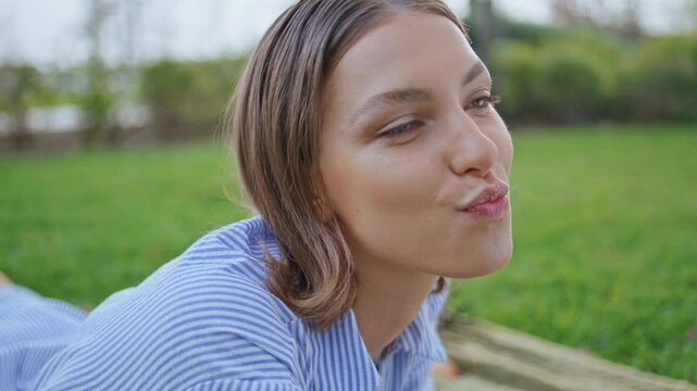 Eating girl enjoying picnic in green park closeup. Portrait of woman chewing 