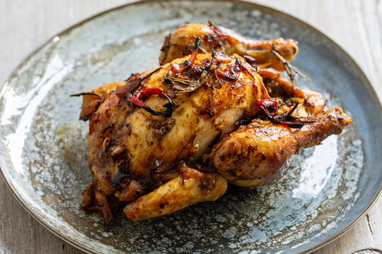 Whole roasted poussin with chilies and rosemary