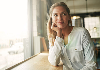 Business woman, happy and thinking in coffee shop, morning and decision for breakfast order in diner. Person, smile and start day at cafe, restaurant and relax with insight for inspiration at store