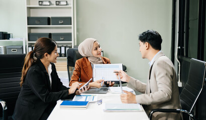  Asian businesspeople while collaborating on a new project.  using a laptop and tablet