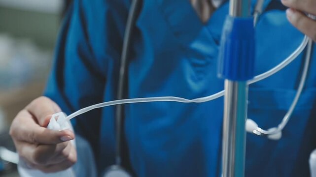 Woman doctor monitor Adjust the drip rate feed of saline dripping intravenous infusion to patient on bed. IV tube or intravenous infusion tube have Sodium Chloride Solution fine tune by doctor.