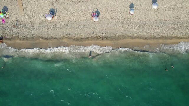 Aerial View of Sandy Beach, People Sunbathing with Umbrellas and Waves Coming of the Coast in Preveza Greece, Monolithi Beach