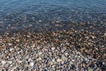 Rocky shore of the Black Sea in the city of Batumi (Georgia). Large pebbles on the shore of the Black Sea. Travel to Georgia.