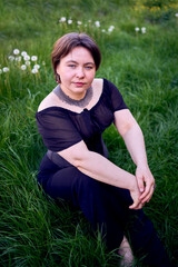 a    medium size woman in a black corset and wide leg trousers walks through the city in the morning light