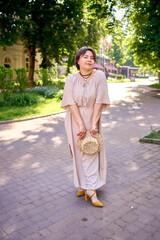 plus size woman in peach fuzz dress with hat having fun on morning city streets