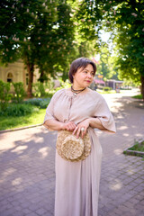 plus size woman in peach fuzz dress with hat having fun on morning city streets