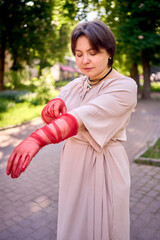plus size woman in peach fuzz dress and red translucent gloves dancing in the morning city streets
