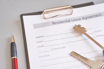 Residential lease agreement with keys and pen on clipboard signifying real estate rental contract.
