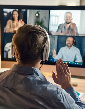 Una persona sorda participando en una videollamada de trabajo, utilizando lenguaje de se&ntilde;as mientras se comunica con su equipo.