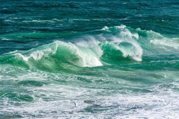 Waves breaking on Ipanema beach on a sunny summer day and the sea with greenish waters