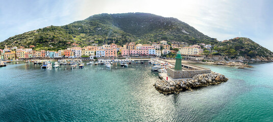 Obraz premium View to harbour and old town of Giglio Porto at Isola del Giglio, island of the tuscan archipelago, beautiful ancient rustico buildings and ferry terminal to Porto San Stefano, Grosseto Tuscany Italy