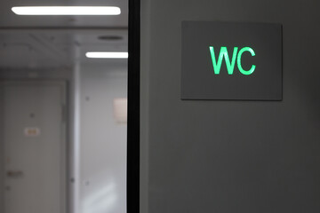 Toilet sign for men and women on train, toilet icon in the form of green WC inscription in public transport, restroom designation for transport passengers