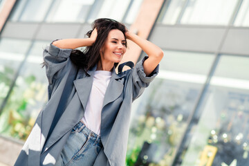 Fototapeta premium Photo of charming positive woman wear grey trench smiling enjoying walk outdoors urban city street