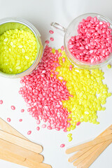 Beauty and Healthcare Concepts. Variety of Colorful Granules of Ready Wax for Depilation in Cups