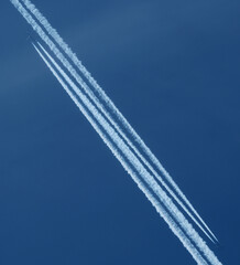Airplane trail in the blue sky, parallel contrails