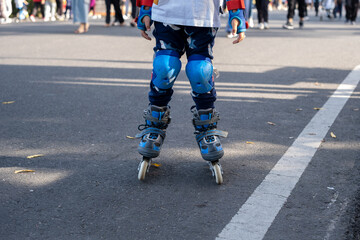 Closeup of a child wearing rollerblades and protective gear