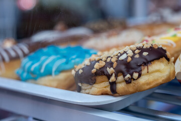 Chocolate Glazed Donut with Topped Nuts in Display Case