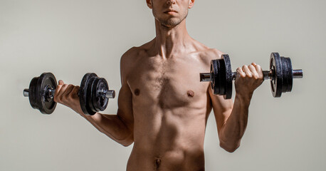 Fototapeta na wymiar Skinny man, dumbbells. Skinny man goes in for sports, builds muscles. Health care concept. Workout gym sport motivation concept. Man holding dumbbell in hand. Thin man in sports with dumbbells