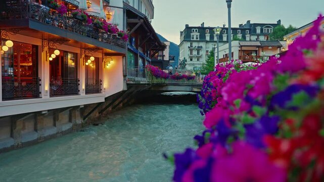 Incredibly beautiful streets of the tourist ski resort of France Chamonix in the summer, tourists walking in the city center along the mountain river and beautifully planted flowers