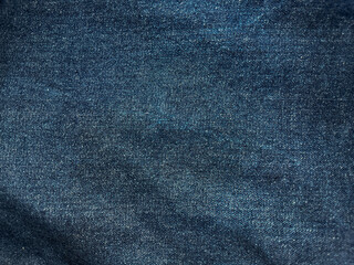 Close-up texture of blue denim fabric with fine fibers clearly visible, giving a detailed...
