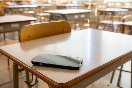 A smartphone on a desk in a classroom owned by a student