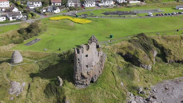 Camera flying over dunure castle and revealing scottish village
