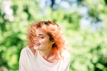 Naklejka premium Portrait of pretty young woman closed eyes flying hair wear t-shirt pastime walk fresh air park outdoors