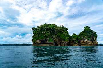 Fototapeta premium Stunning Tropical Scenery of Isla de los Pájaros in Bocas del Toro, Panama Featuring Lush Vegetation, Wildlife, and Dramatic Coastal Rock Formations in the Caribbean Sea