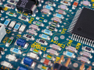 Close-up of microcircuits and components: chips, diodes and capacitors on a printed circuit board,...