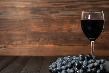 Red Wine and Grapes on Rustic Wooden Background