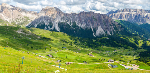 panoramic view of rocky mountain and blanket-like grass covered valley in summer, Seceda,...