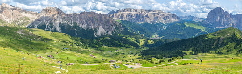 panoramic view of rocky mountain and blanket-like grass covered valley in summer, Seceda, Dolomites, Italy © Echo