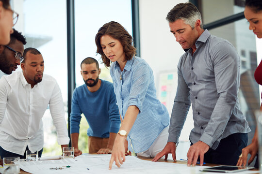 Architecture, business people and group with blueprint in office for planning home remodeling project. Collaboration, architect team and pointing to floor plan for building design, draft or diversity
