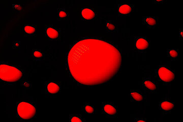 Milk red drops scattered on a black background. Abstract image with liquids.