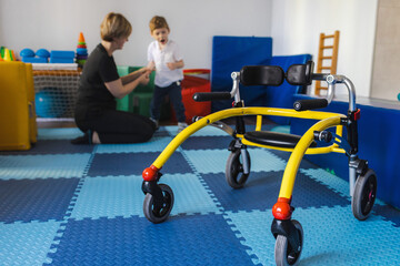Young boy with cerebral palsy participates in physical therapy assisted by a therapist in a vibrant...