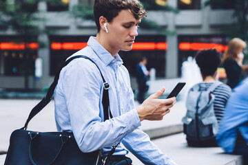 Experienced male lawyer in formal wear using 4g wireless and bluetooth headphones for listening...