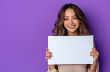 A woman is holding a blank piece of paper and smiling. Concept of positivity and optimism, as the woman is holding the blank paper with a smile on her face