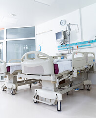 A hospital room with two beds and a clock on the wall. The room is clean and well-lit, giving off a sense of calm and order