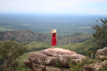 mulher de vestido vermelho e chapéu no mirante Alto do Céu, na Chapada dos Guimarães, Mato Grosso 