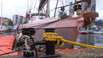 Close-up of two ship mooring cables tied to the pier, holding the ship in place, providing stability and preventing it from drifting.