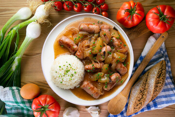 Sausages cooked with onion and pear. Top view table with 
 decoration.